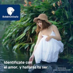Mujer vestida de blanco tocando el agua en un entorno natural, simbolizando la conexión con el amor interior.