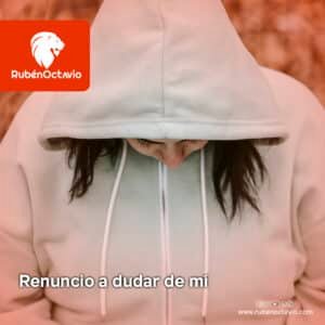 Mujer con sudadera inclinando la cabeza en señal de introspección, representando el acto de renunciar a la duda interior.