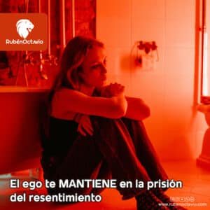 Mujer sentada en un baño con luz roja, simbolizando la prisión emocional del resentimiento causada por el ego.