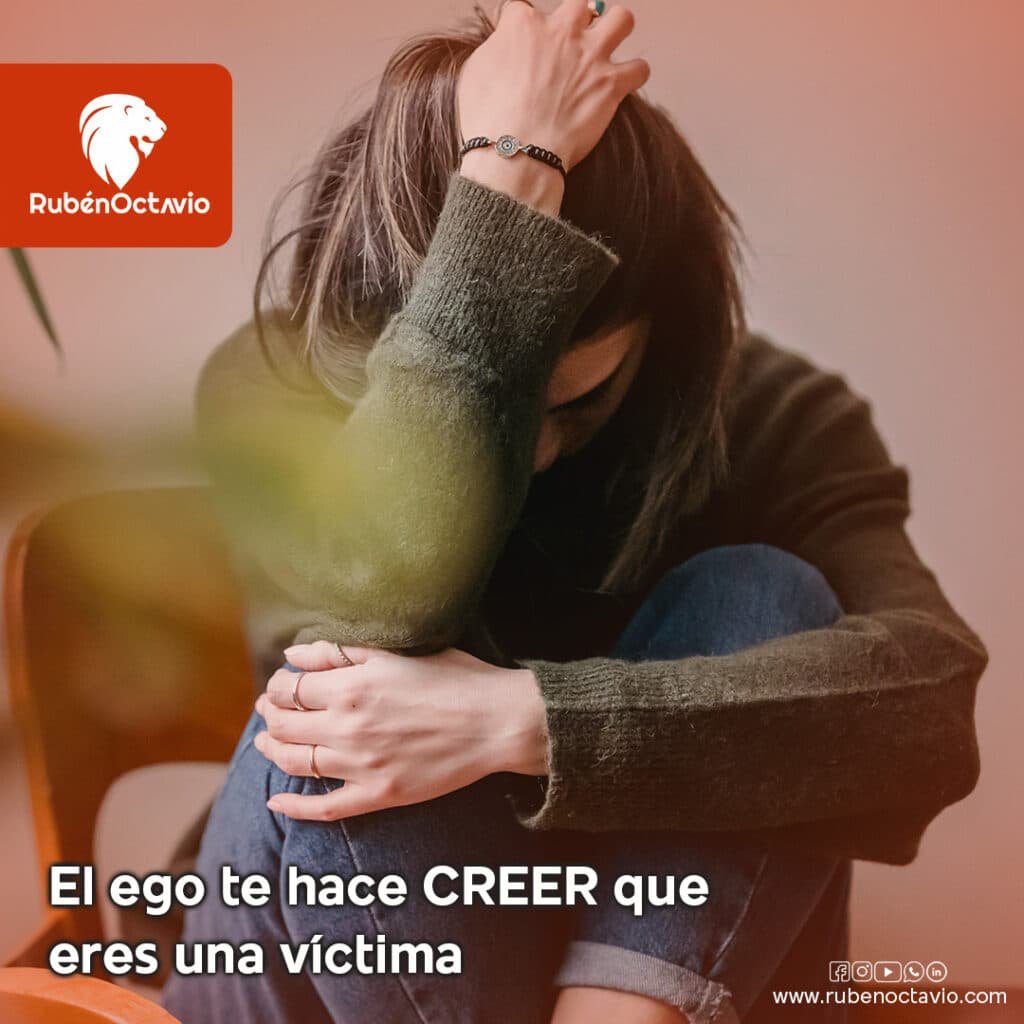 Persona sentada con postura de angustia, representando la ilusión del ego de sentirse víctima.