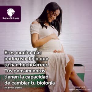 Mujer embarazada sonriendo y tocando su abdomen, simbolizando el poder de los pensamientos en la biología y el bienestar.