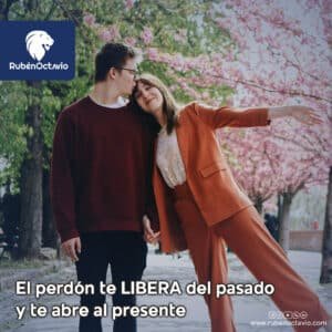 Pareja caminando entre árboles floridos, simbolizando la liberación del pasado a través del perdón.