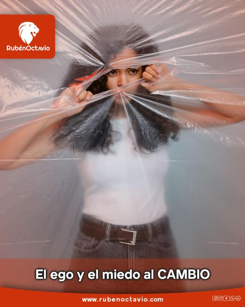 Mujer rompiendo una lámina plástica, simbolizando el miedo al cambio y la liberación del ego.