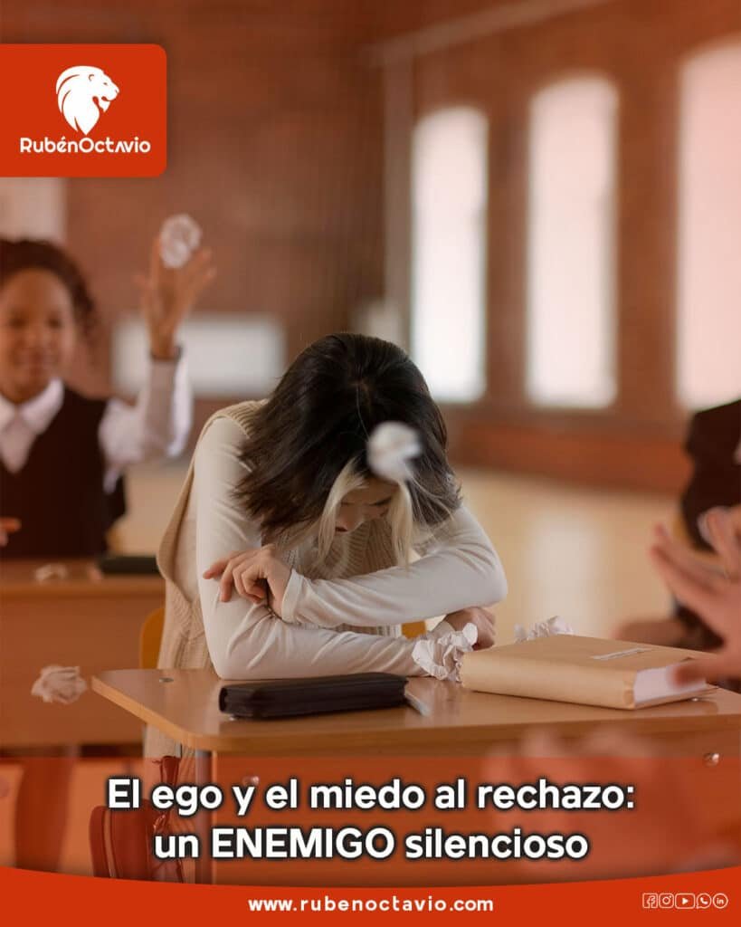 Persona con la cabeza baja en un salón de clases mientras otros la rechazan, simbolizando el impacto emocional del miedo al rechazo.