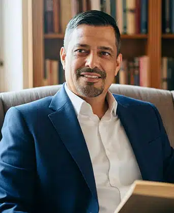 Rubén Octavio sonriendo en oficina; psicoeducación para la paz interior.