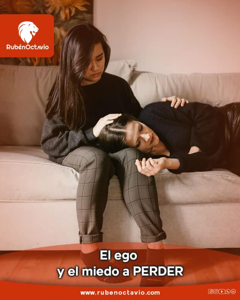 Dos personas abrazándose en un sofá, reflejando el miedo del ego a perder y la búsqueda de apoyo emocional.