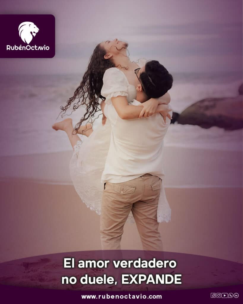 Pareja abrazándose con alegría en la playa, simbolizando el amor verdadero que libera y expande.