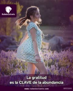 Joven sonriendo en un campo de flores simbolizando gratitud y abundancia.