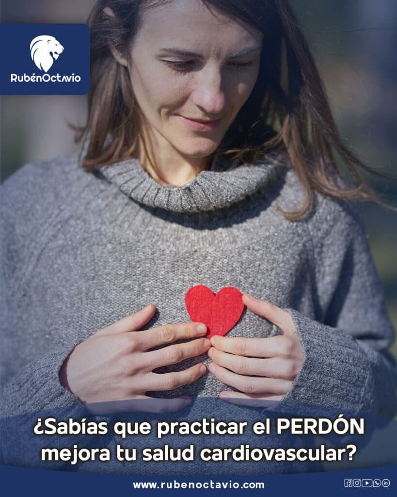 Mujer sosteniendo un corazón rojo sobre su pecho mientras reflexiona sobre el perdón y la sanación emocional.