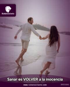 Pareja tomada de la mano caminando hacia el mar al atardecer, simbolizando paz y retorno a la inocencia.