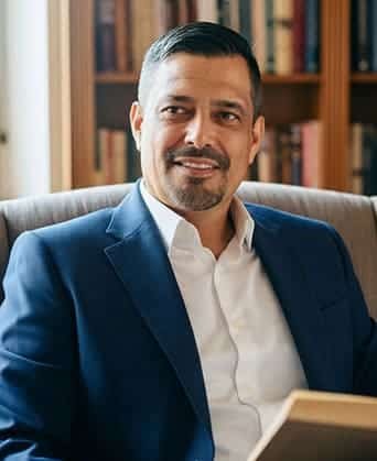 Rubén Octavio sonriendo en oficina; psicoeducación para la paz interior.