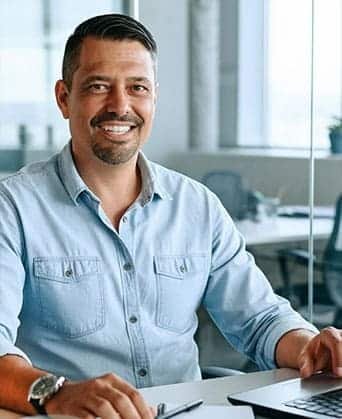 Rubén Octavio sonriendo en su escritorio, psicoterapeuta y psicoeducador.