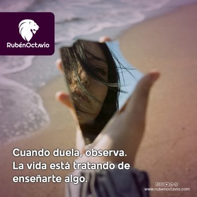 Mujer mirando su reflejo en un espejo roto sobre la arena, simbolizando autoobservación y aprendizaje interior.