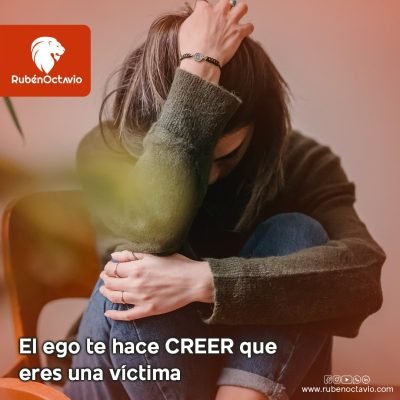 Persona sentada con postura de angustia, representando la ilusión del ego de sentirse víctima.