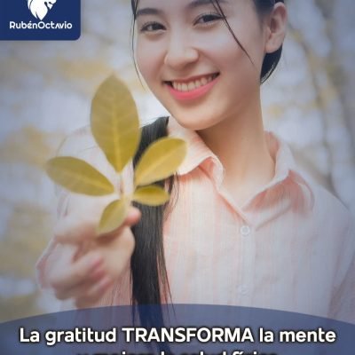 Mujer sonriendo mientras sostiene una rama de hojas, simbolizando la gratitud y el bienestar emocional.