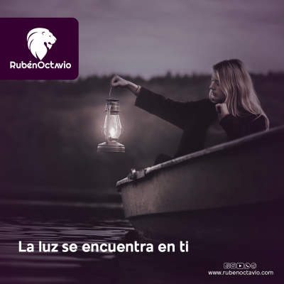 Mujer sosteniendo una lámpara encendida sobre un lago al atardecer.