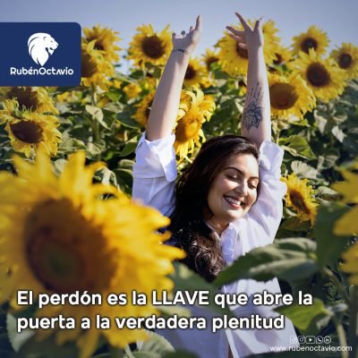 Mujer sonriendo entre girasoles con los brazos arriba, simbolizando la libertad que trae el perdón.